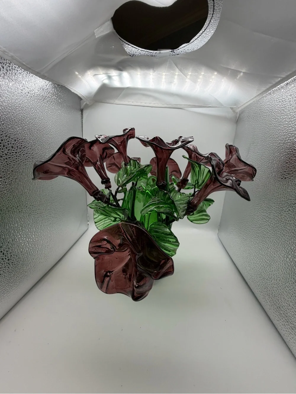 Vintage green swing glass vase with purple lily trumpet flowers.